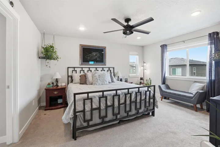 Bedroom with ceiling fan, light carpet, and recessed lighting