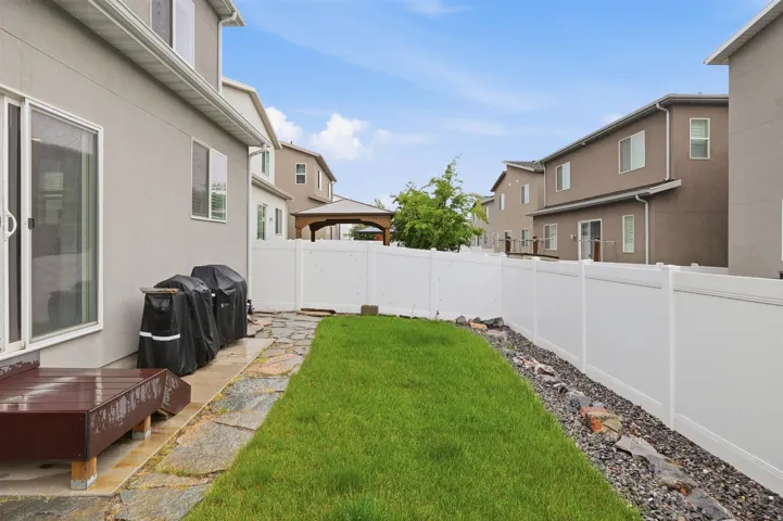 Fenced backyard featuring a gazebo and a patio