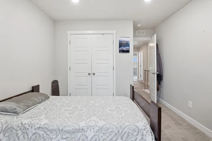 Bedroom with light carpet, a closet, and recessed lighting