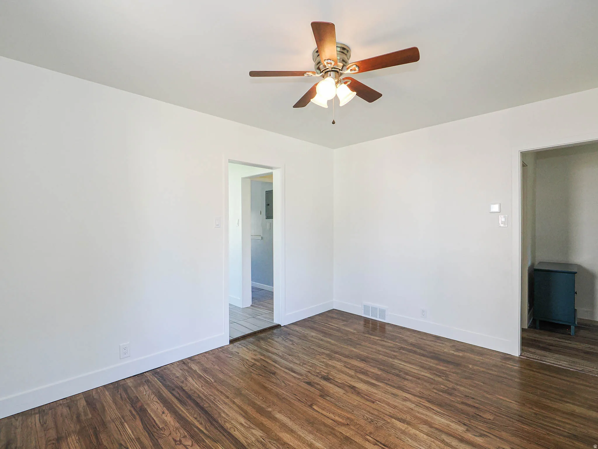 Unfurnished room with dark wood-style floors and a ceiling fan