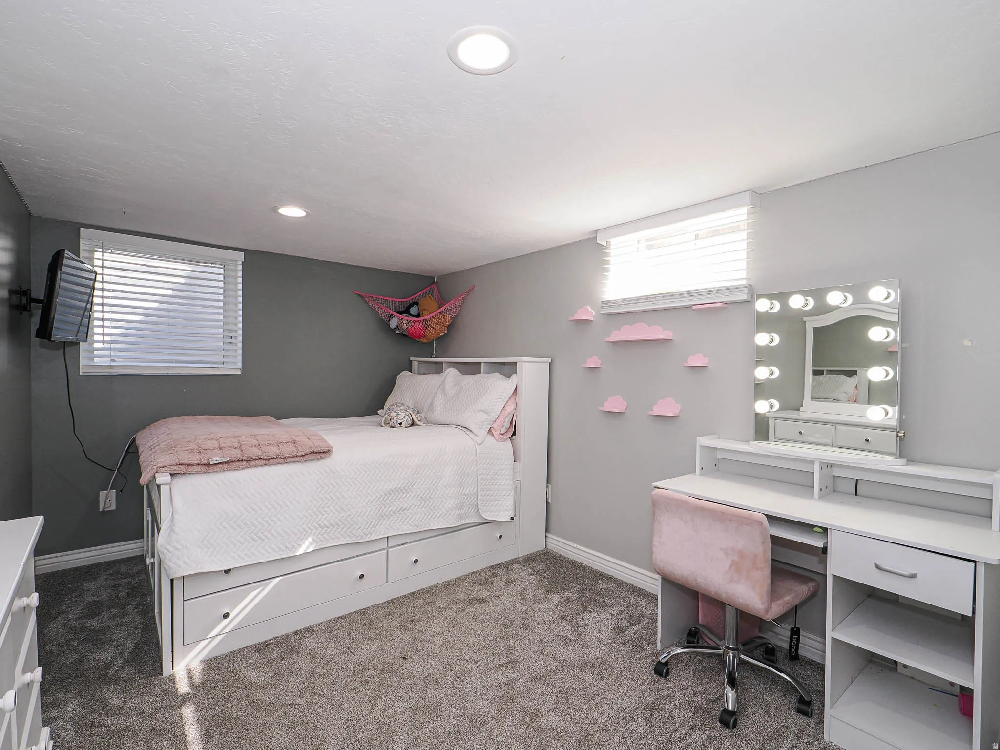 Carpeted bedroom featuring baseboards and an office area