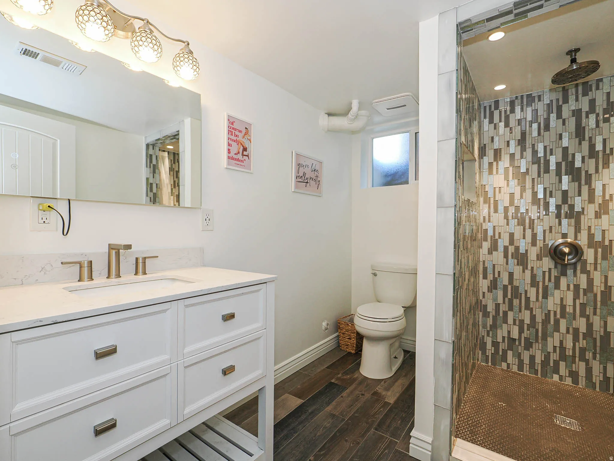 Full bathroom featuring vanity, dark wood-style flooring, and a tile shower