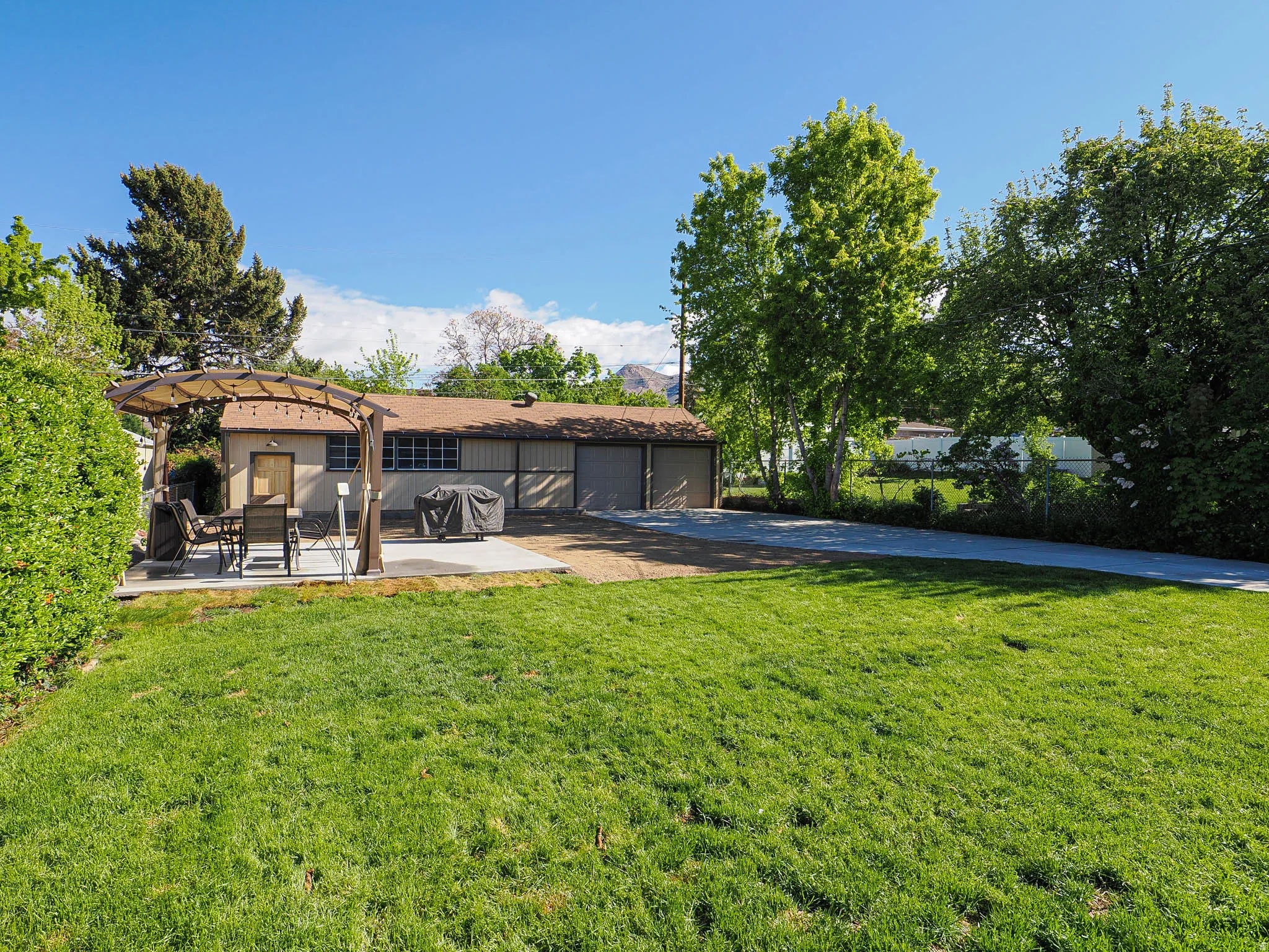 Rear view of house with a pergola, a patio, a garage, and driveway