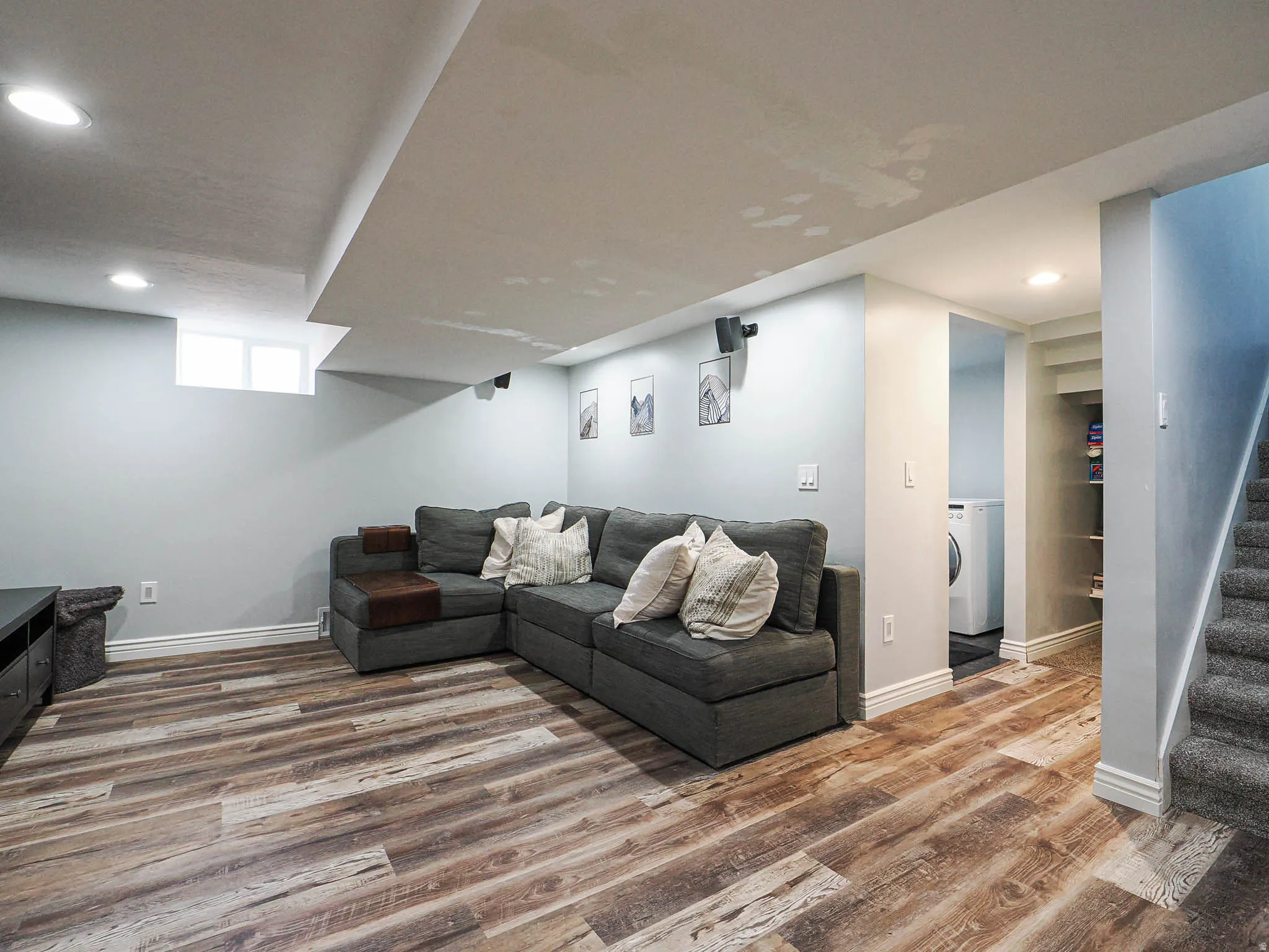 Living room featuring wood finished floors, recessed lighting, and washer / clothes dryer