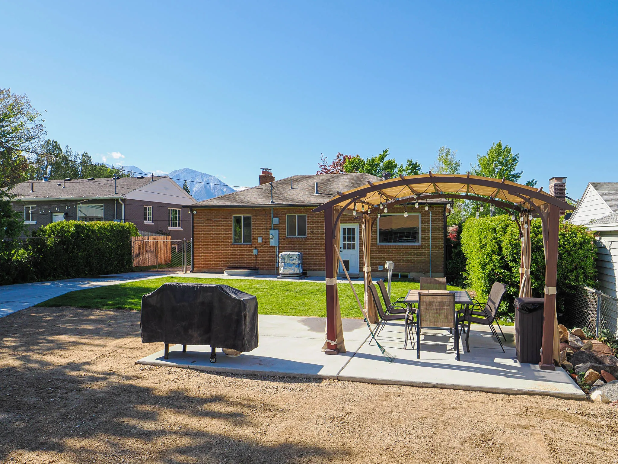 Back of house with a patio area, brick siding, a mountain view, outdoor dining area, and a pergola