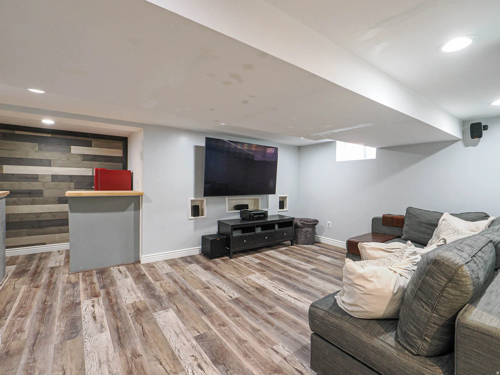 Living room with light wood-style flooring and recessed lighting