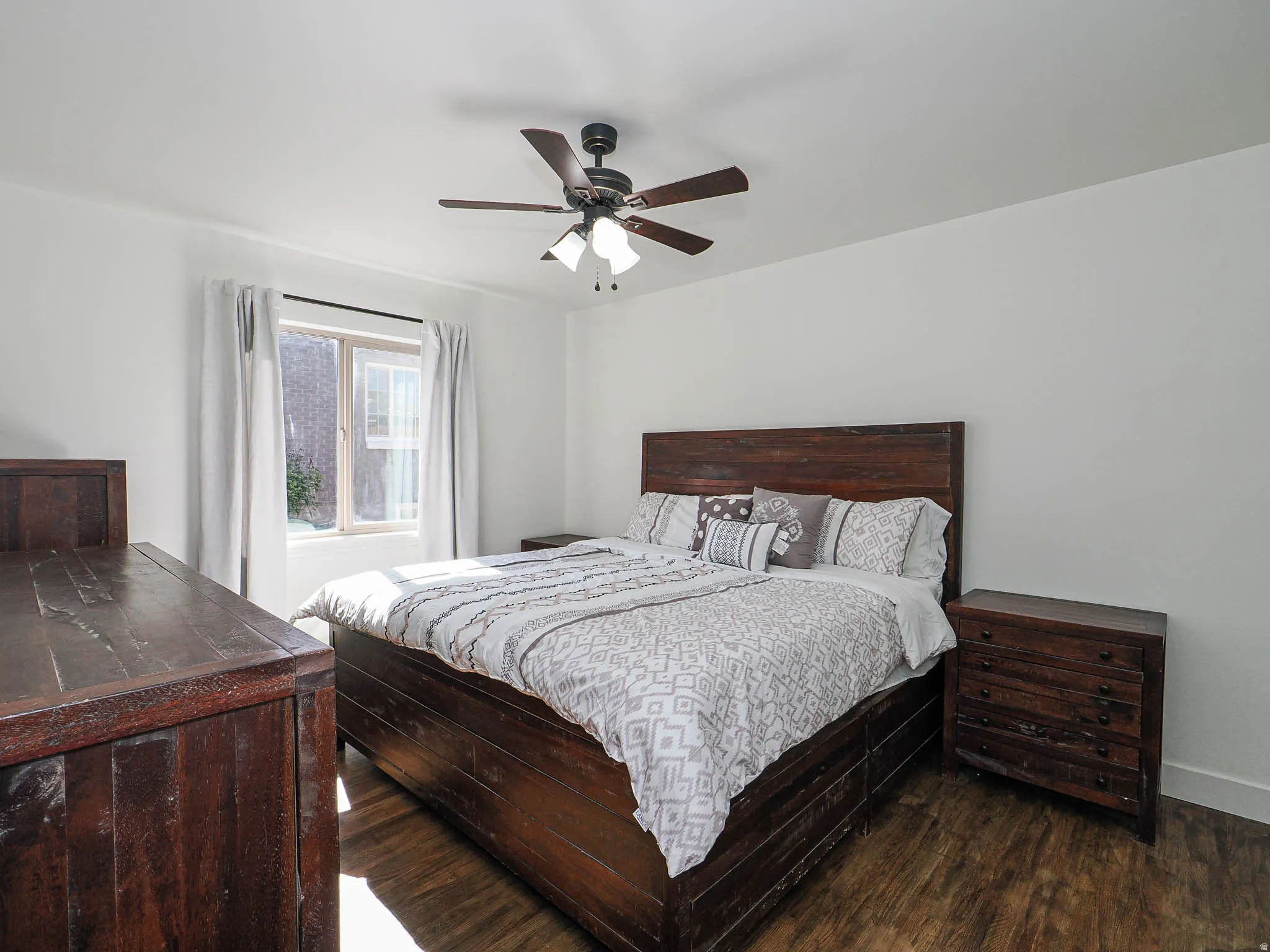 Bedroom with dark wood-style flooring and ceiling fan
