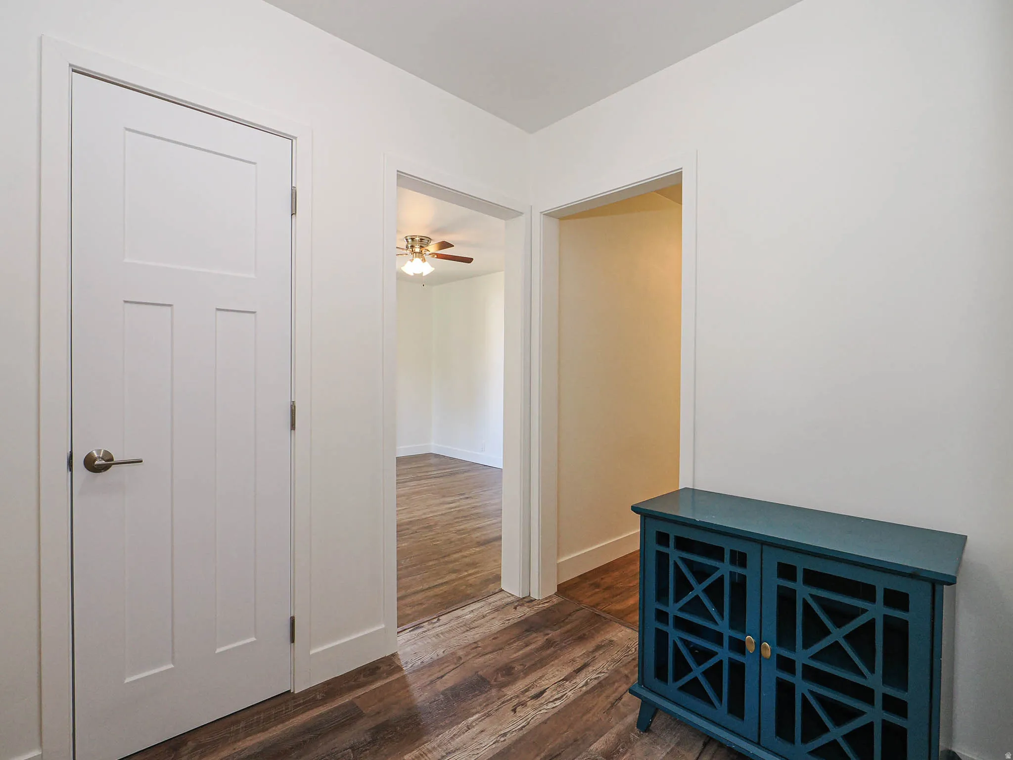 Hallway with dark wood-style flooring and baseboards