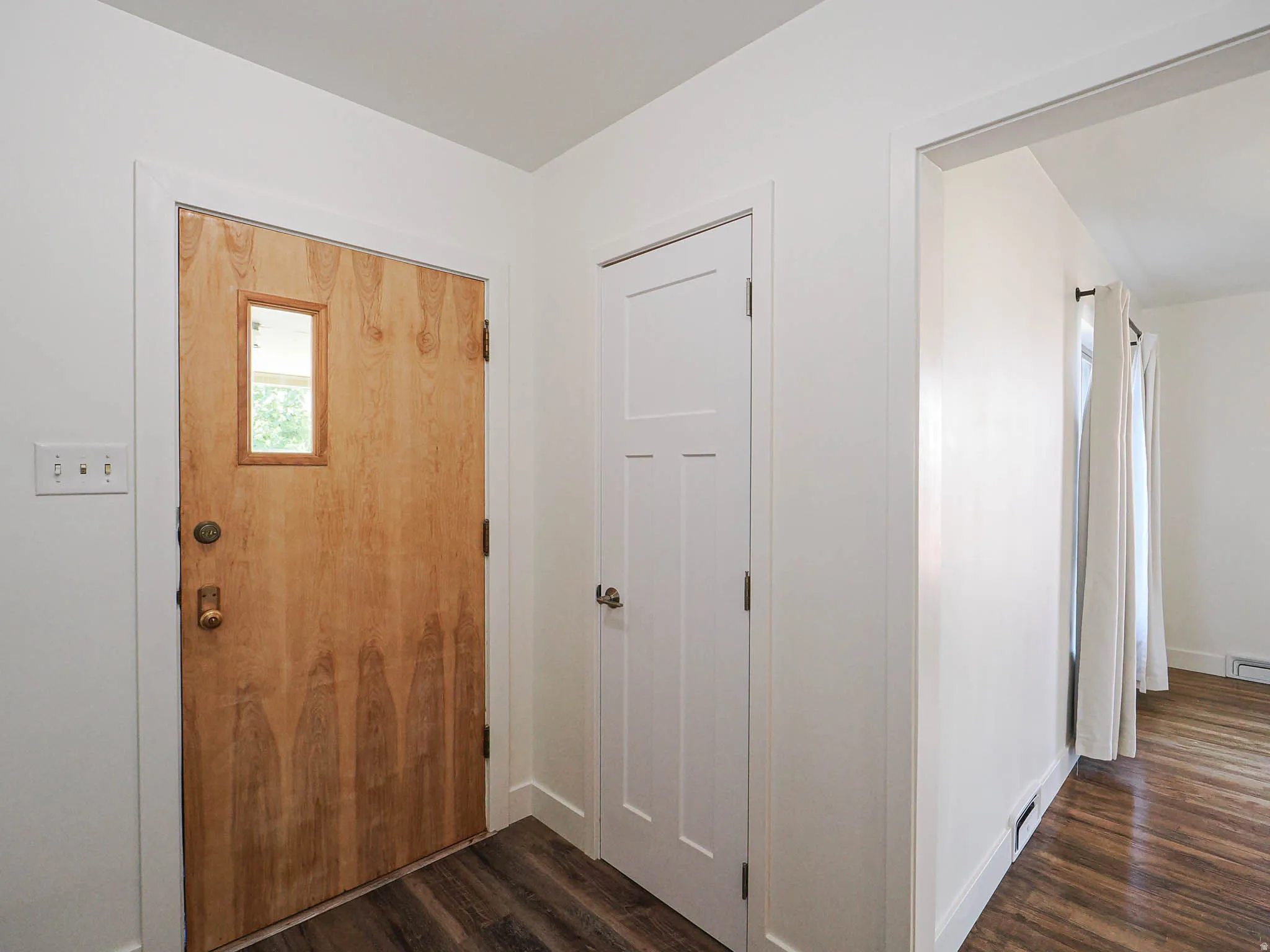 Entryway featuring dark wood-style flooring and baseboards