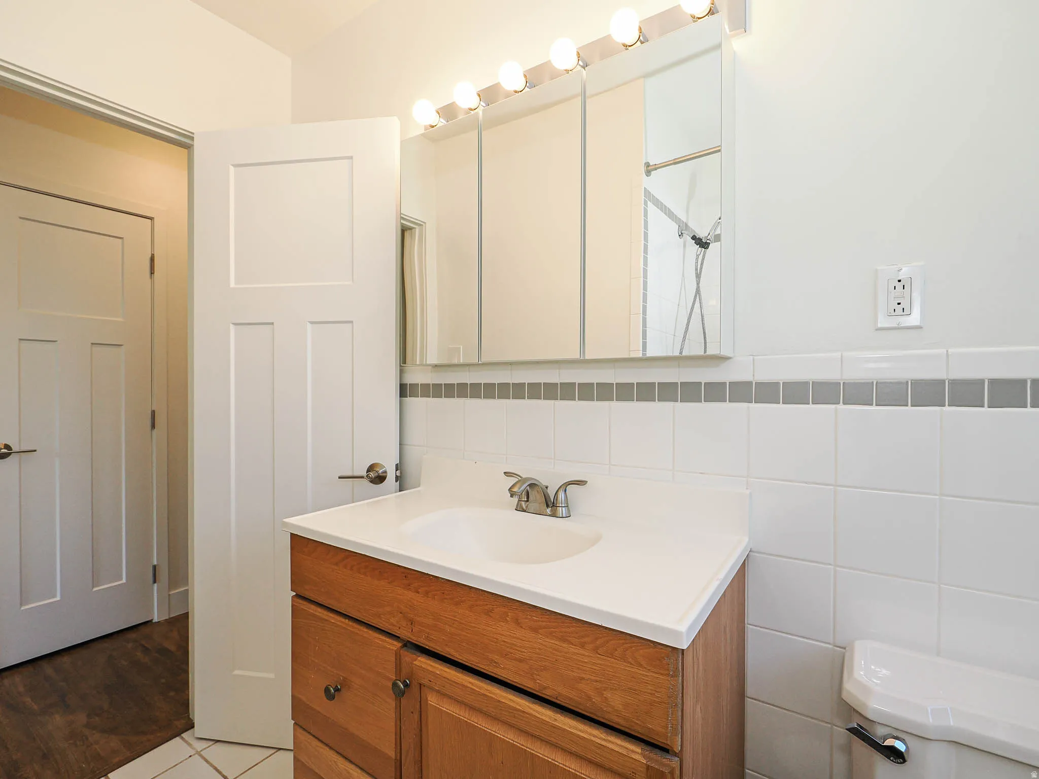 Bathroom featuring vanity, tile walls, and light tile patterned floors
