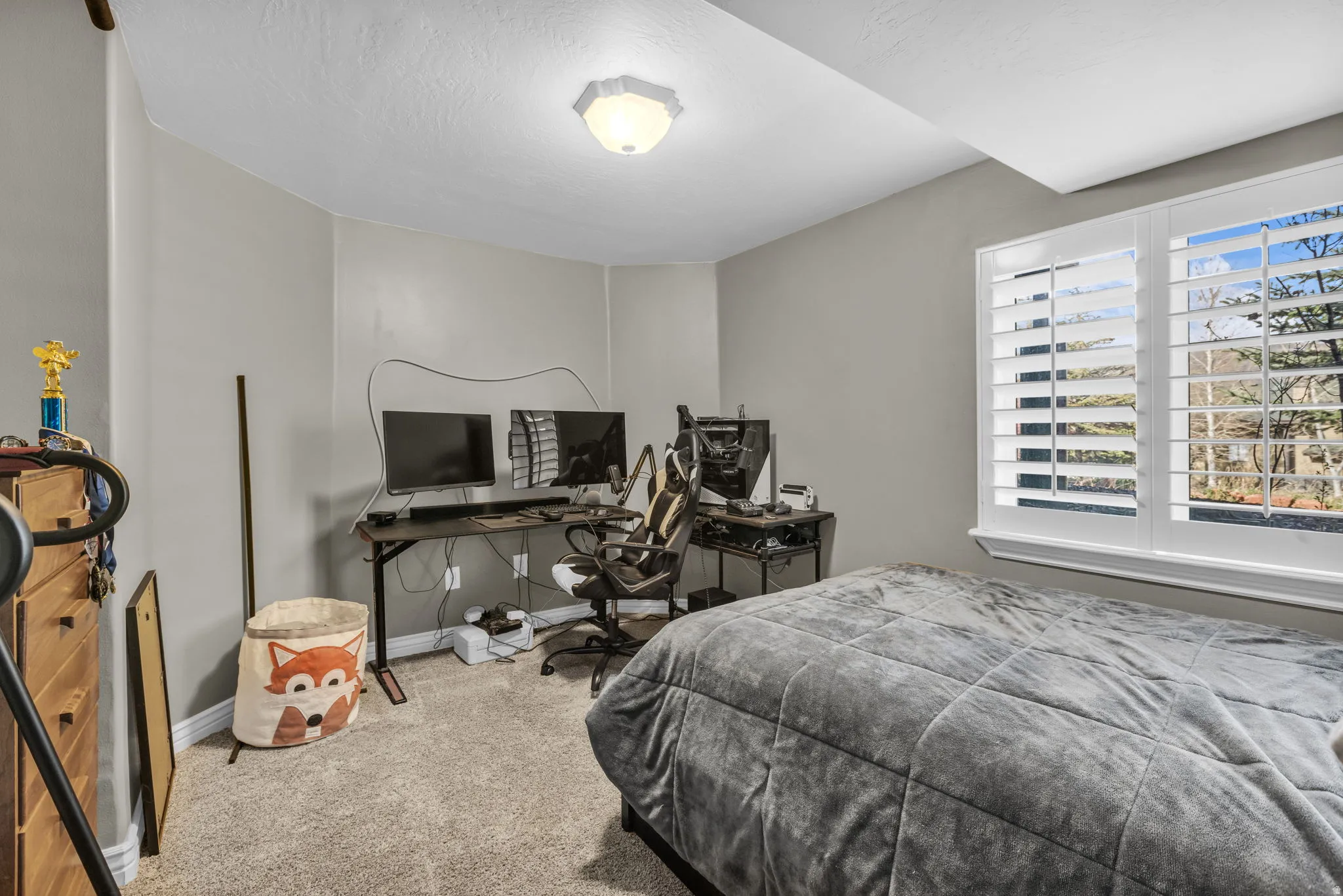 Carpeted bedroom featuring a desk and baseboards