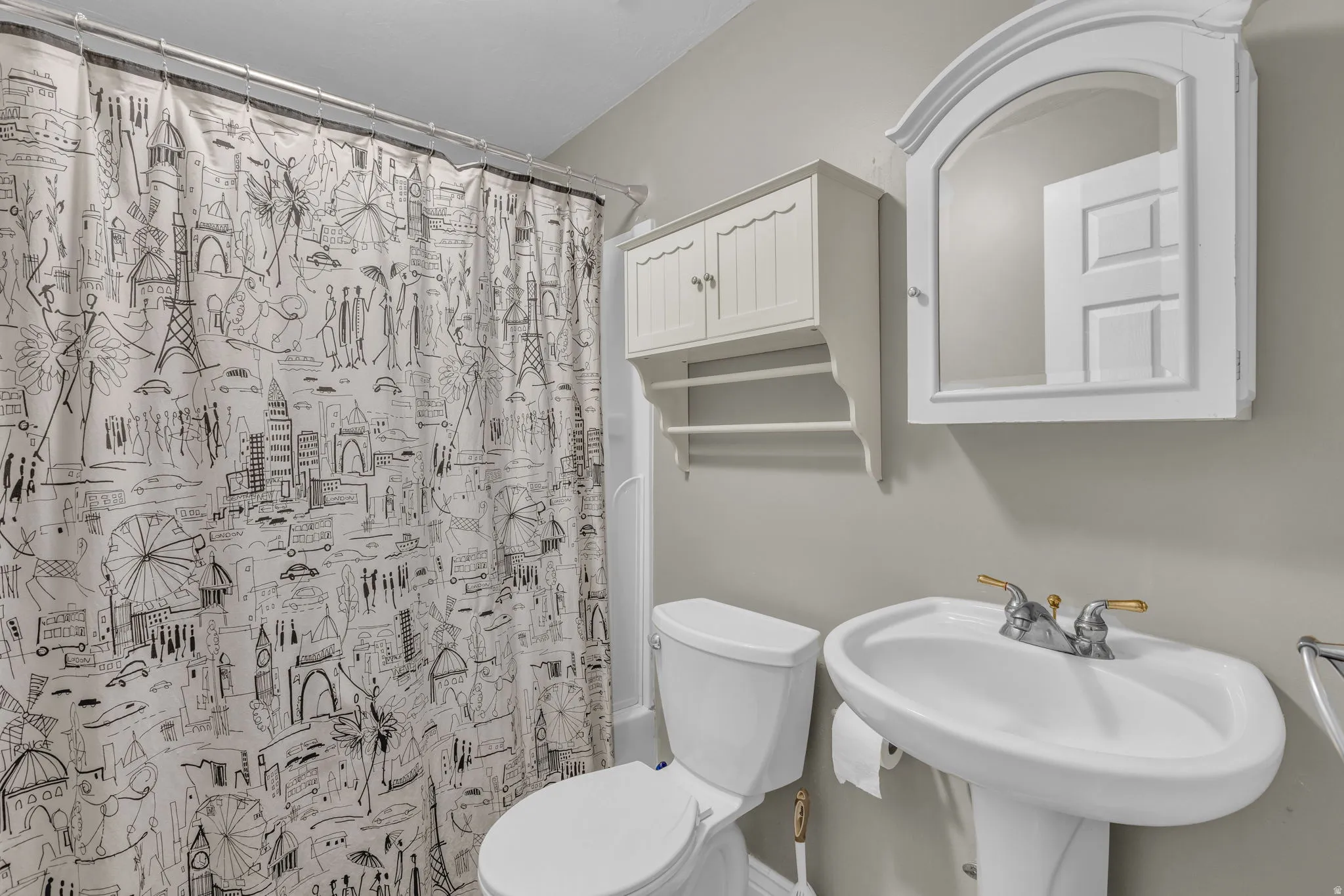 Bathroom featuring toilet and curtained shower
