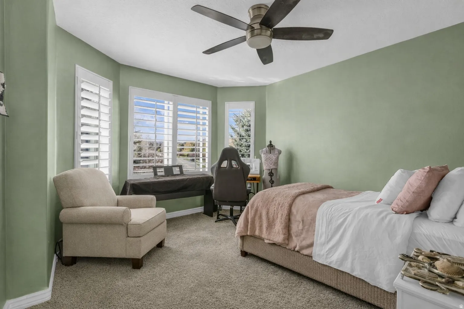 Carpeted bedroom with ceiling fan and baseboards