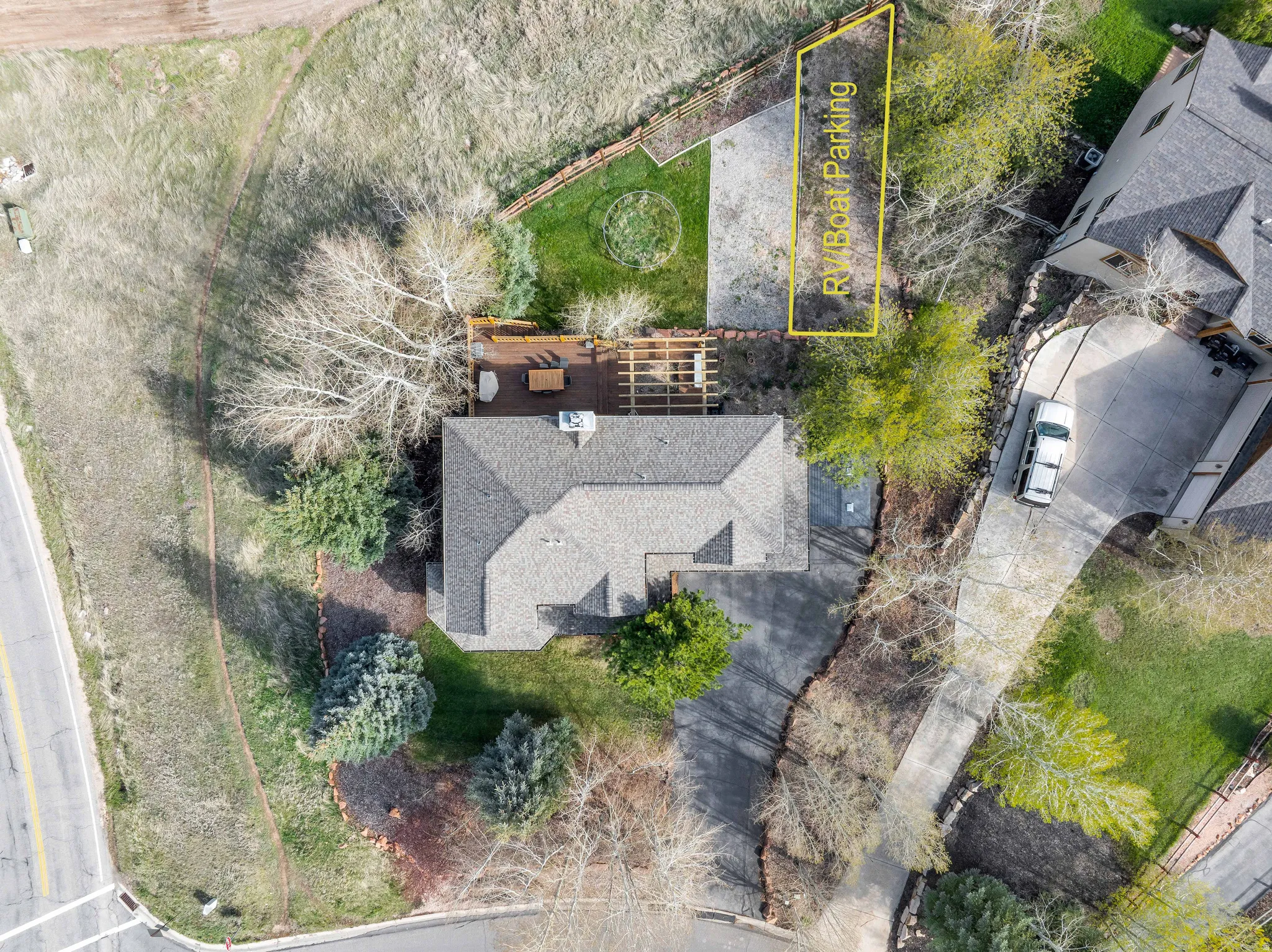 Property featuring a shingled roof, a paved driveway, and a wooden deck