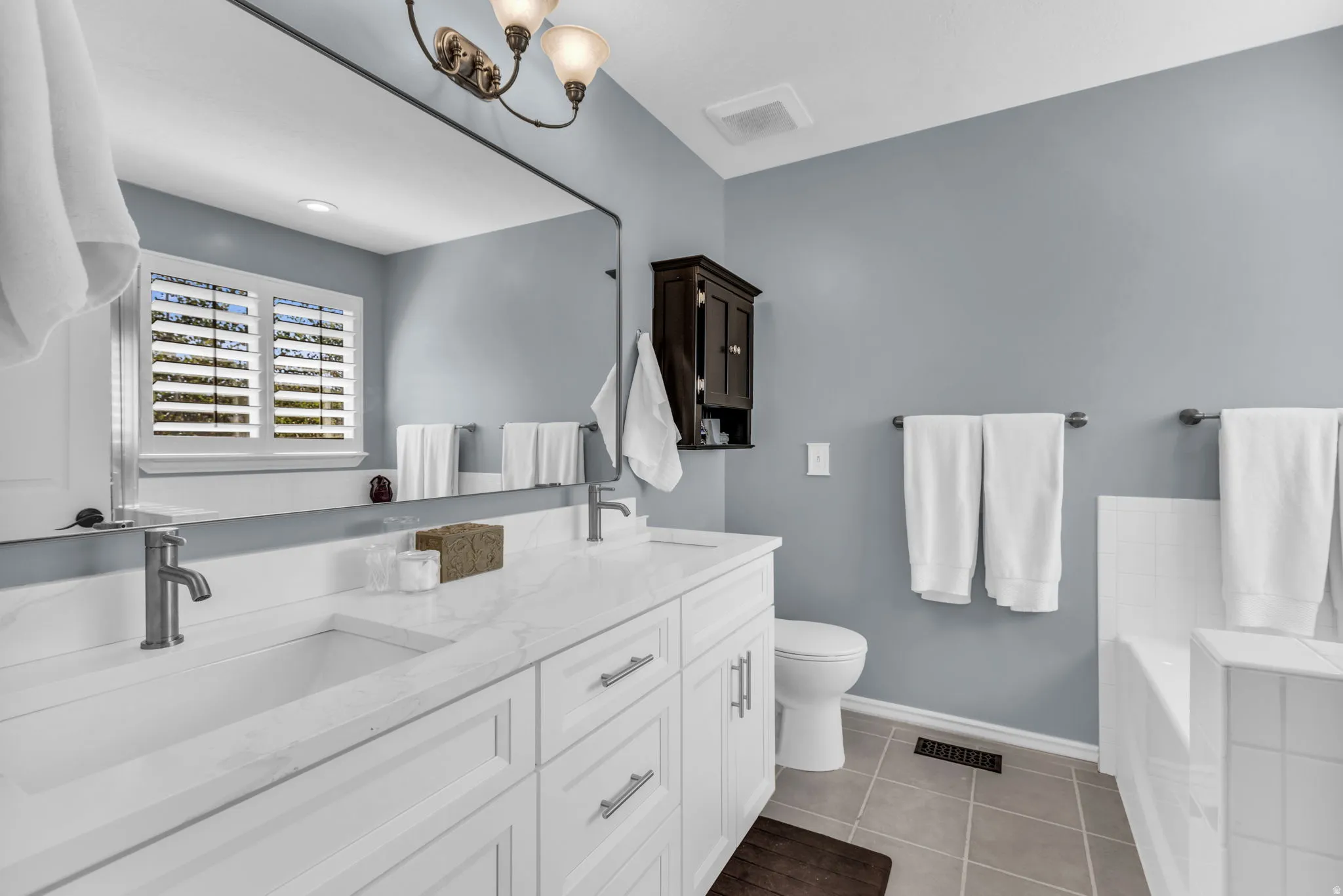 Double vanity with white cabinetry, integrated sinks, and brushed nickel fixtures