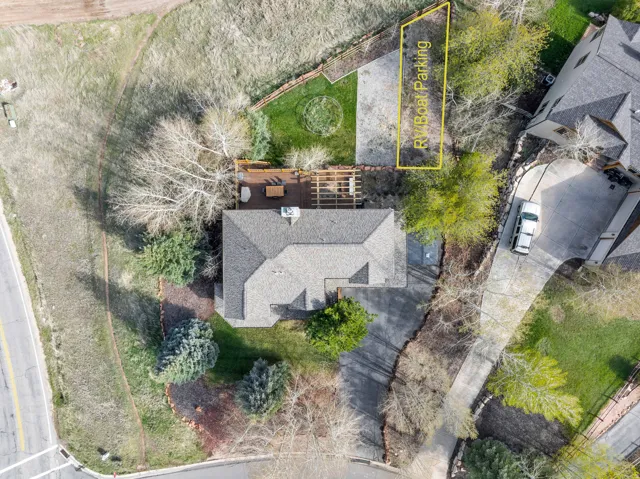 Property featuring a shingled roof, a paved driveway, and a wooden deck