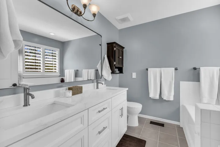 Double vanity with white cabinetry, integrated sinks, and brushed nickel fixtures