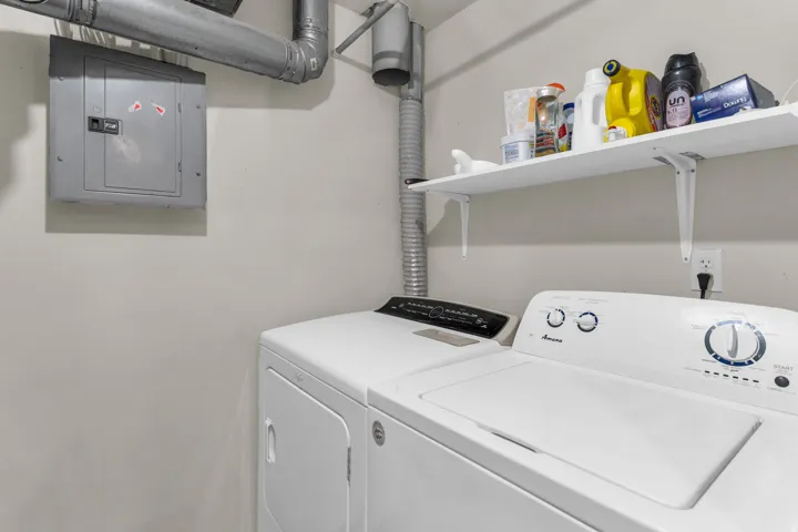 Laundry room with electric panel and washing machine and dryer