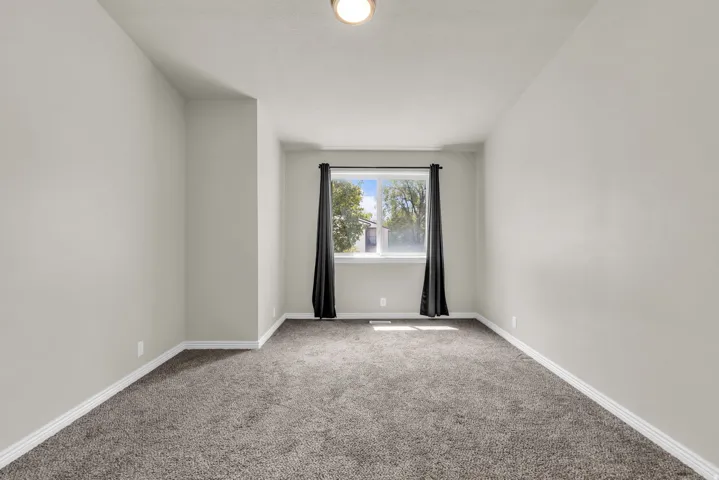 Empty room with carpet flooring and baseboards