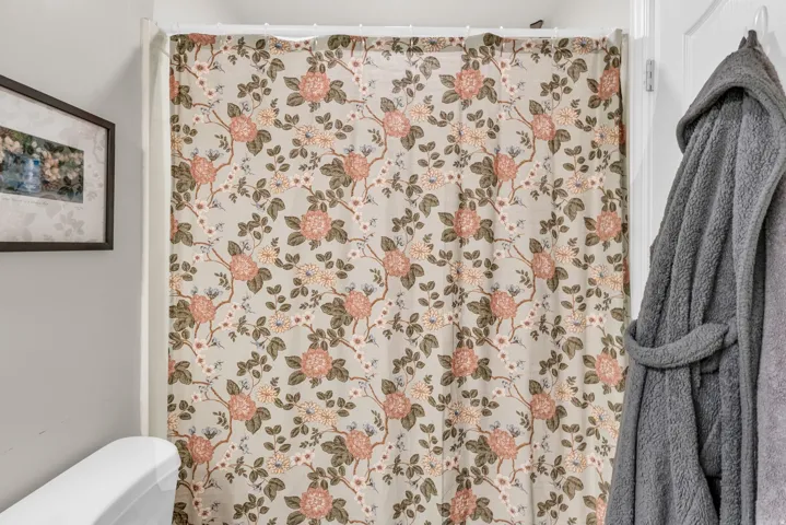 Full bathroom featuring a shower with shower curtain and toilet