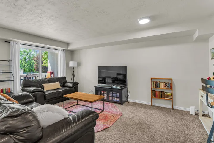 Carpeted living room with a textured ceiling