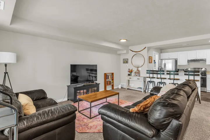 Living area featuring baseboards and light carpet