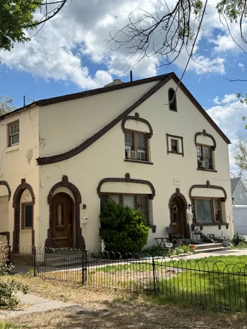 View of front facade featuring a fenced front yard, stucco siding, and cooling unit