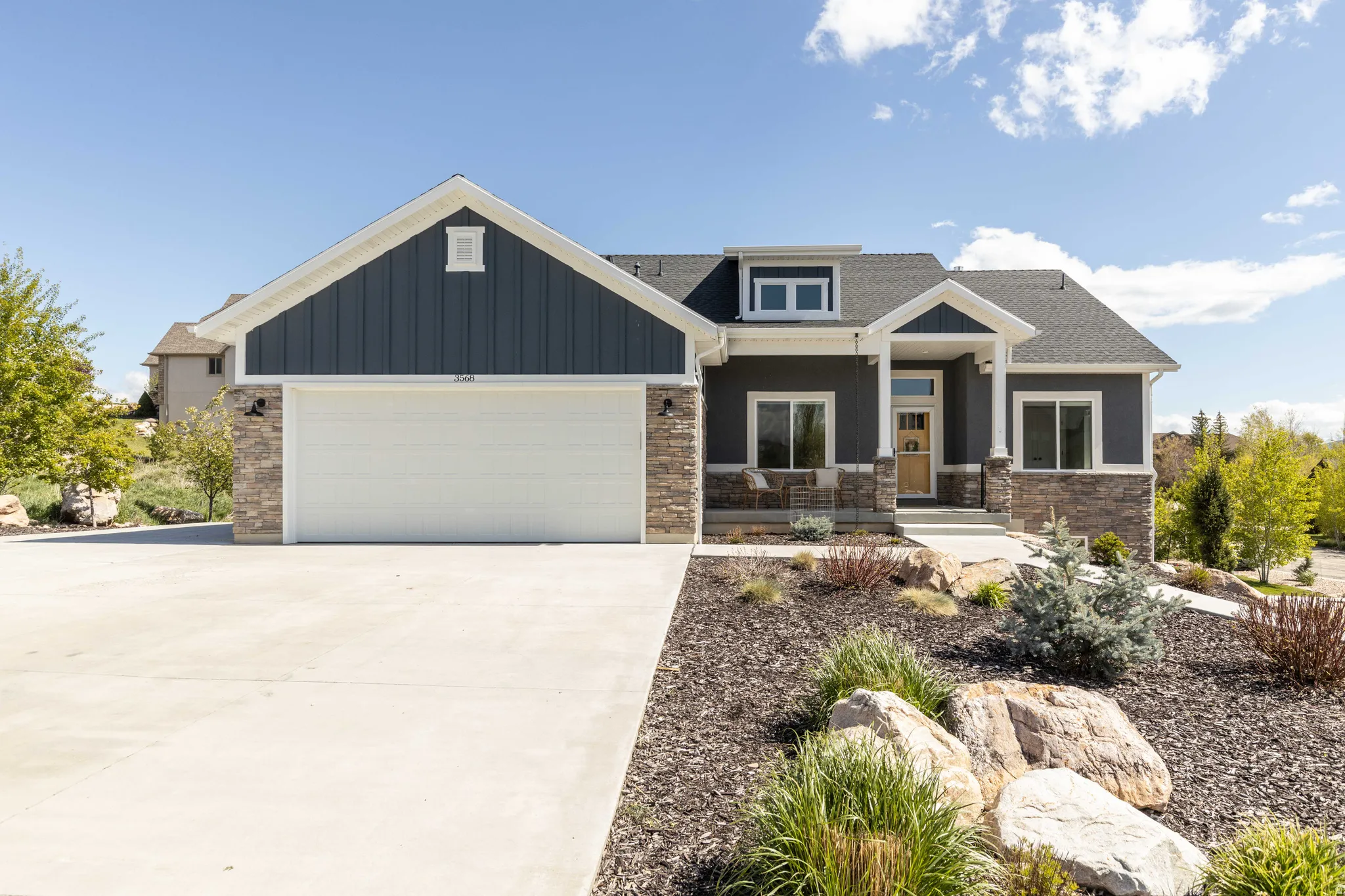 Craftsman-style home featuring a porch, a garage, driveway, and a shingled roof