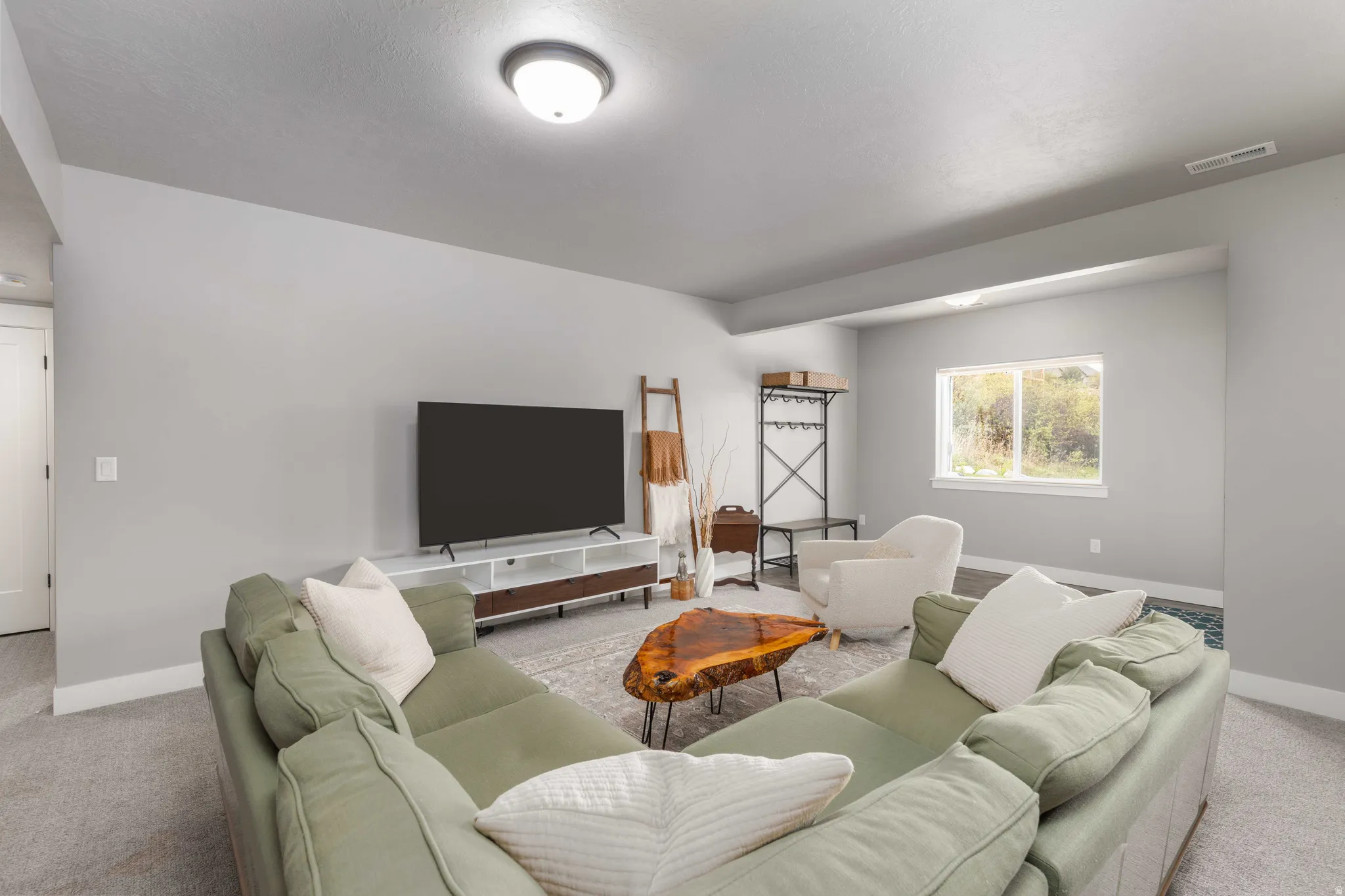 Living area with light carpet and baseboards