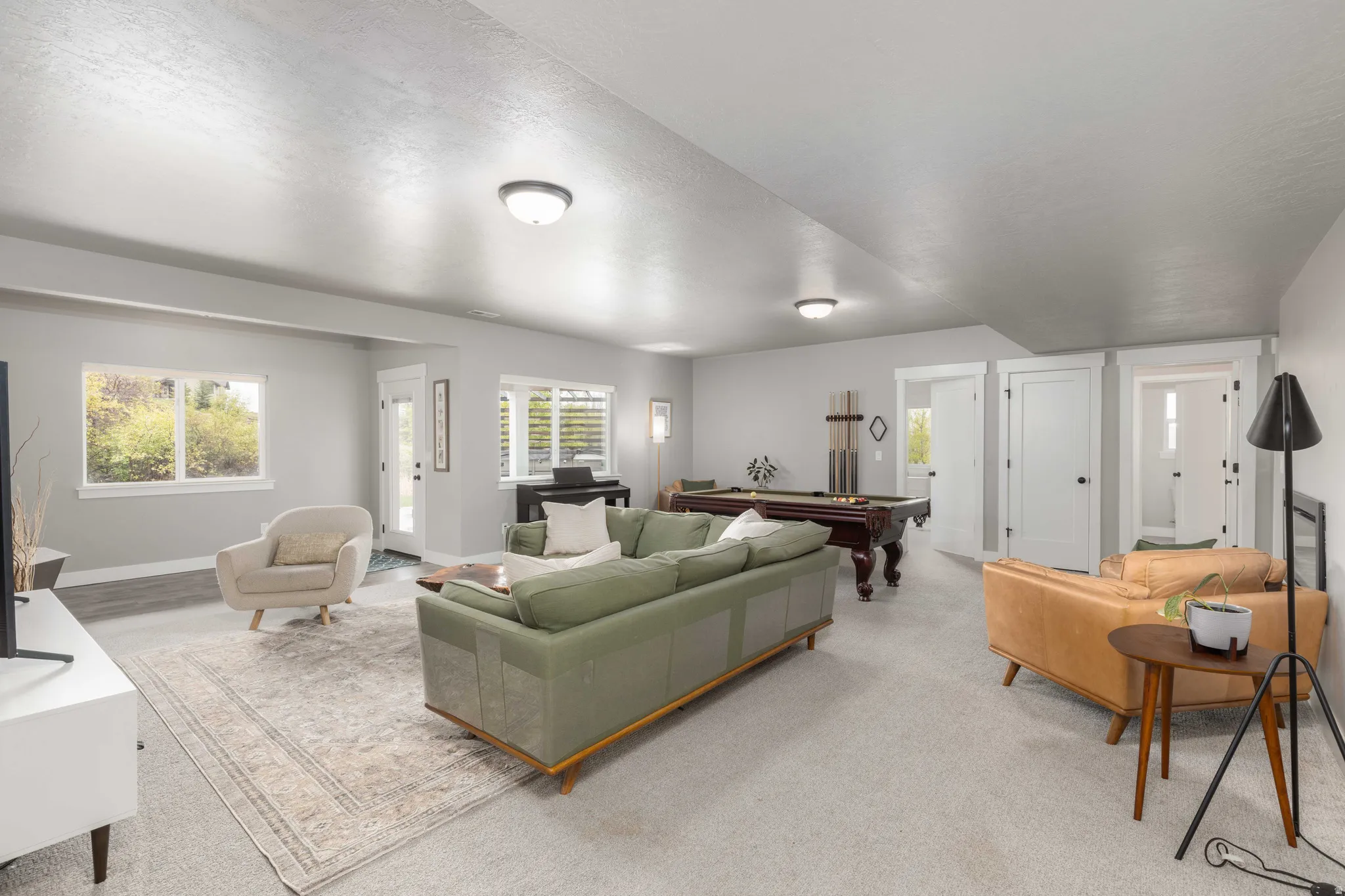 Carpeted living area featuring billiards and baseboards