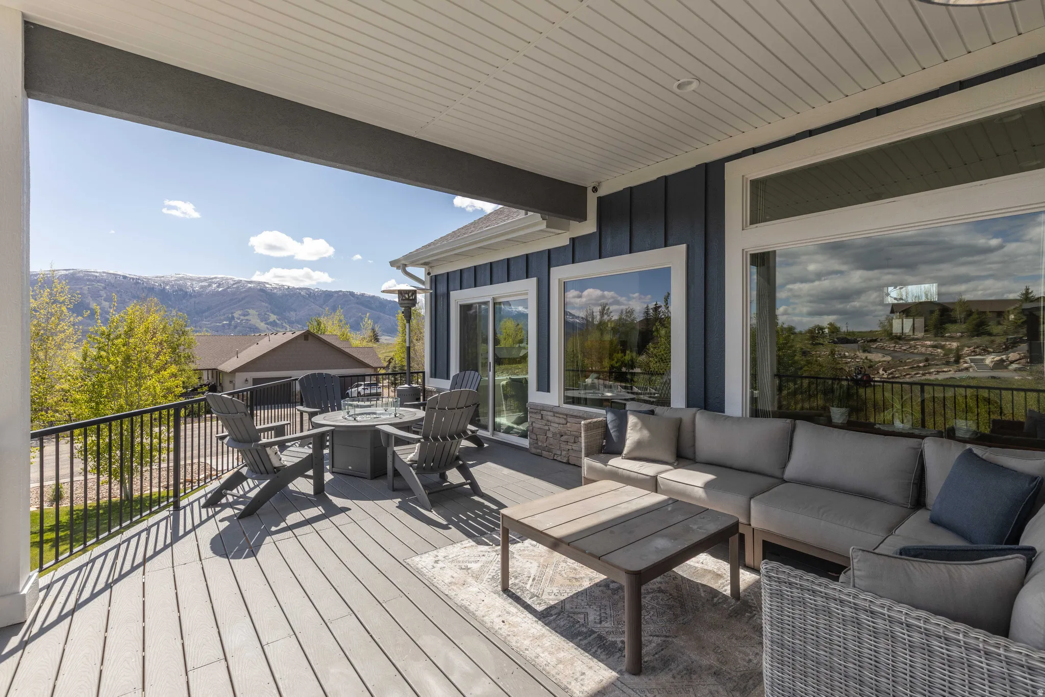 Wooden deck with an outdoor living space with a fire pit and a mountain view