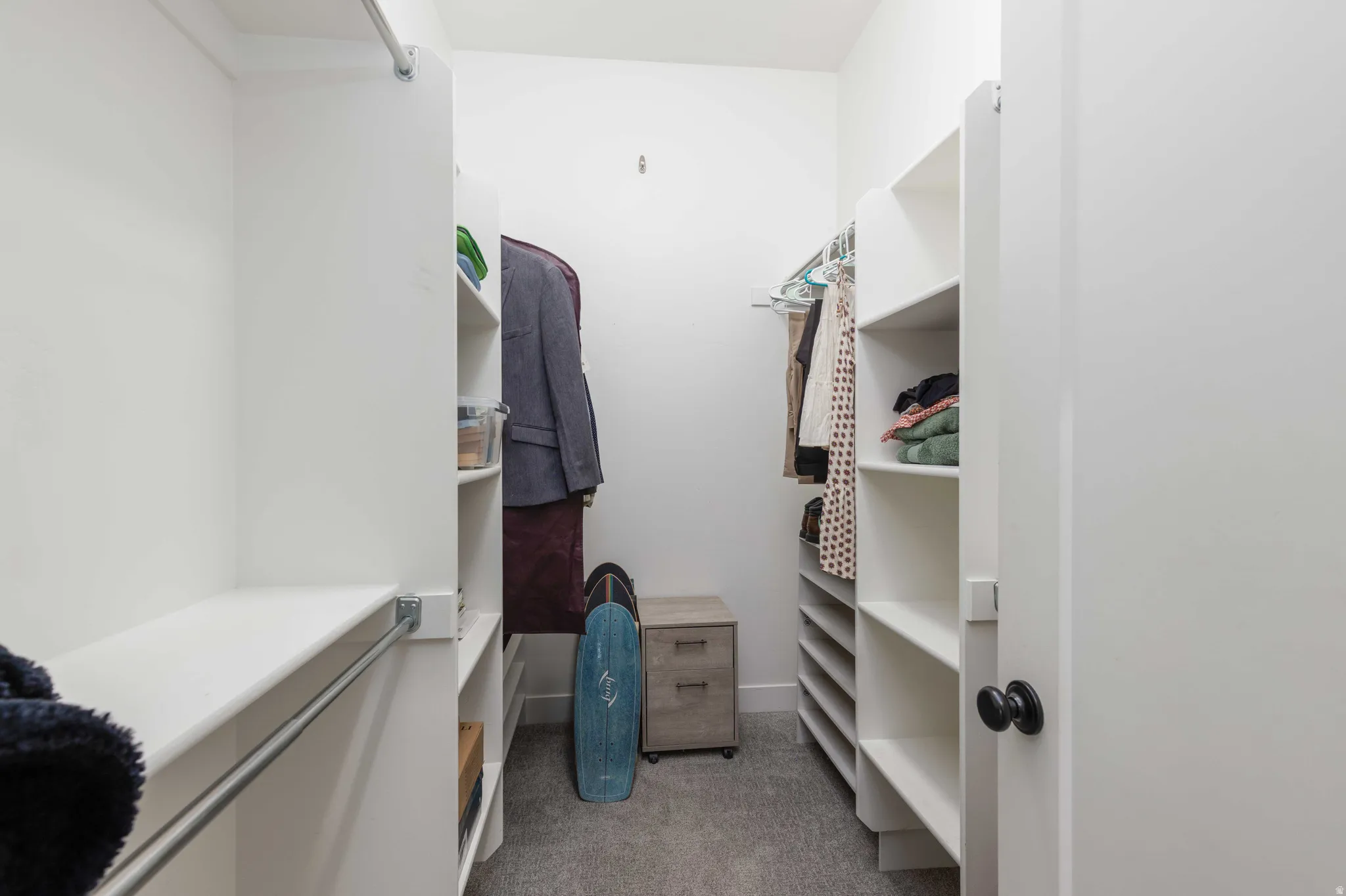 Walk in closet with light colored carpet