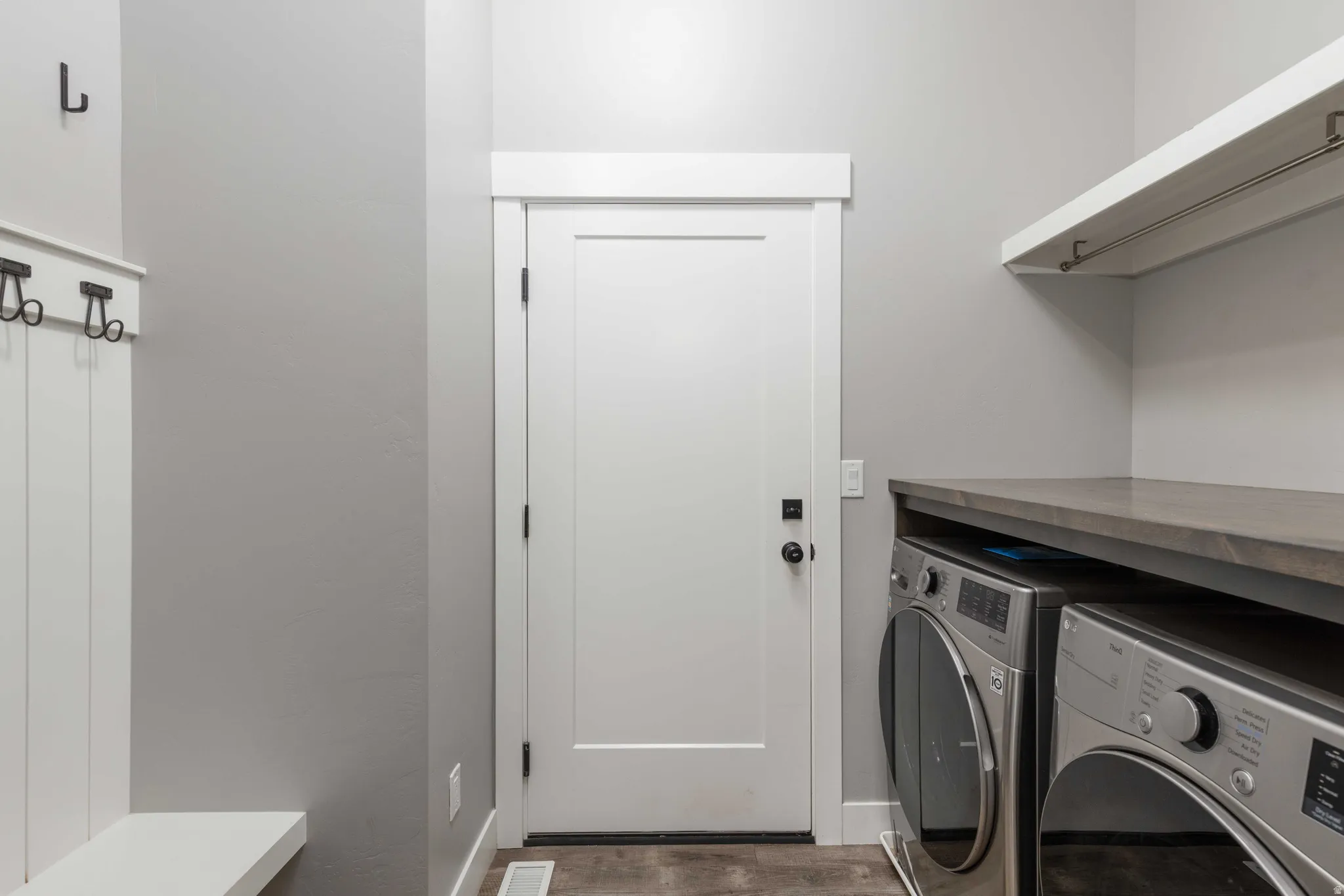 Laundry room featuring separate washer and dryer and dark wood-style floors