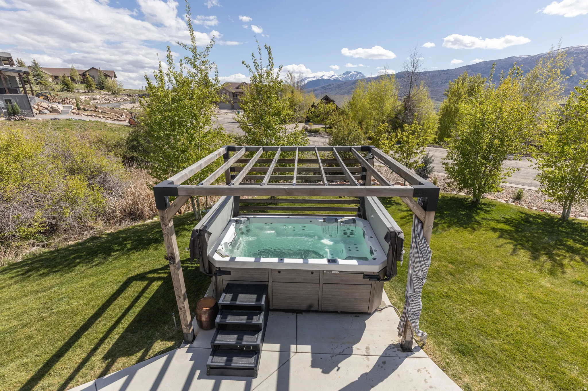 View of patio with a mountain view and a hot tub