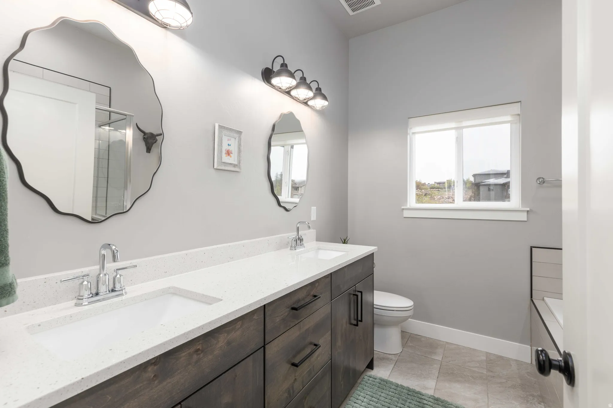 Bathroom featuring double vanity and toilet