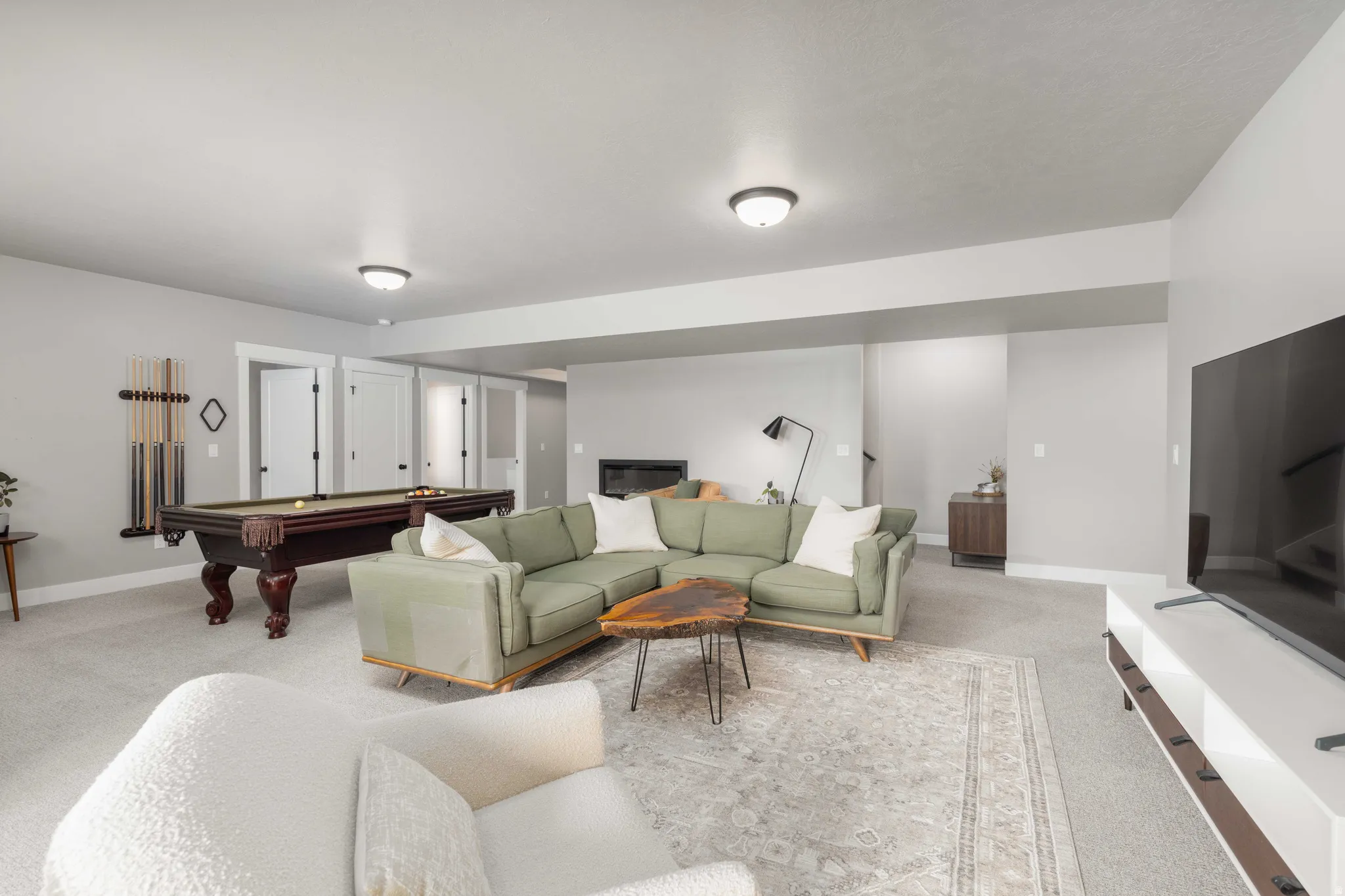 Living room with billiards table and light colored carpet
