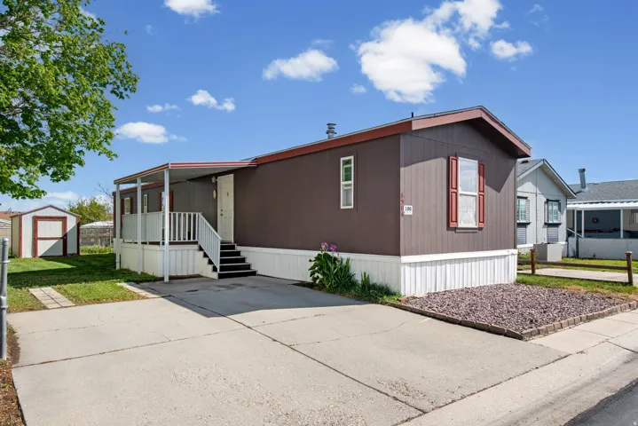 Manufactured / mobile home featuring a storage shed and covered porch