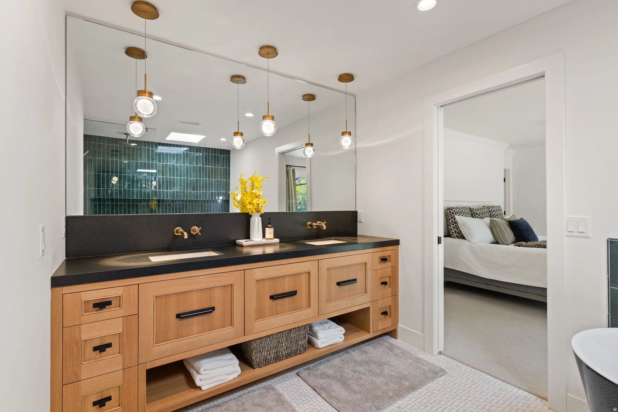 Ensuite bathroom with double vanity, a tile shower, and recessed lighting