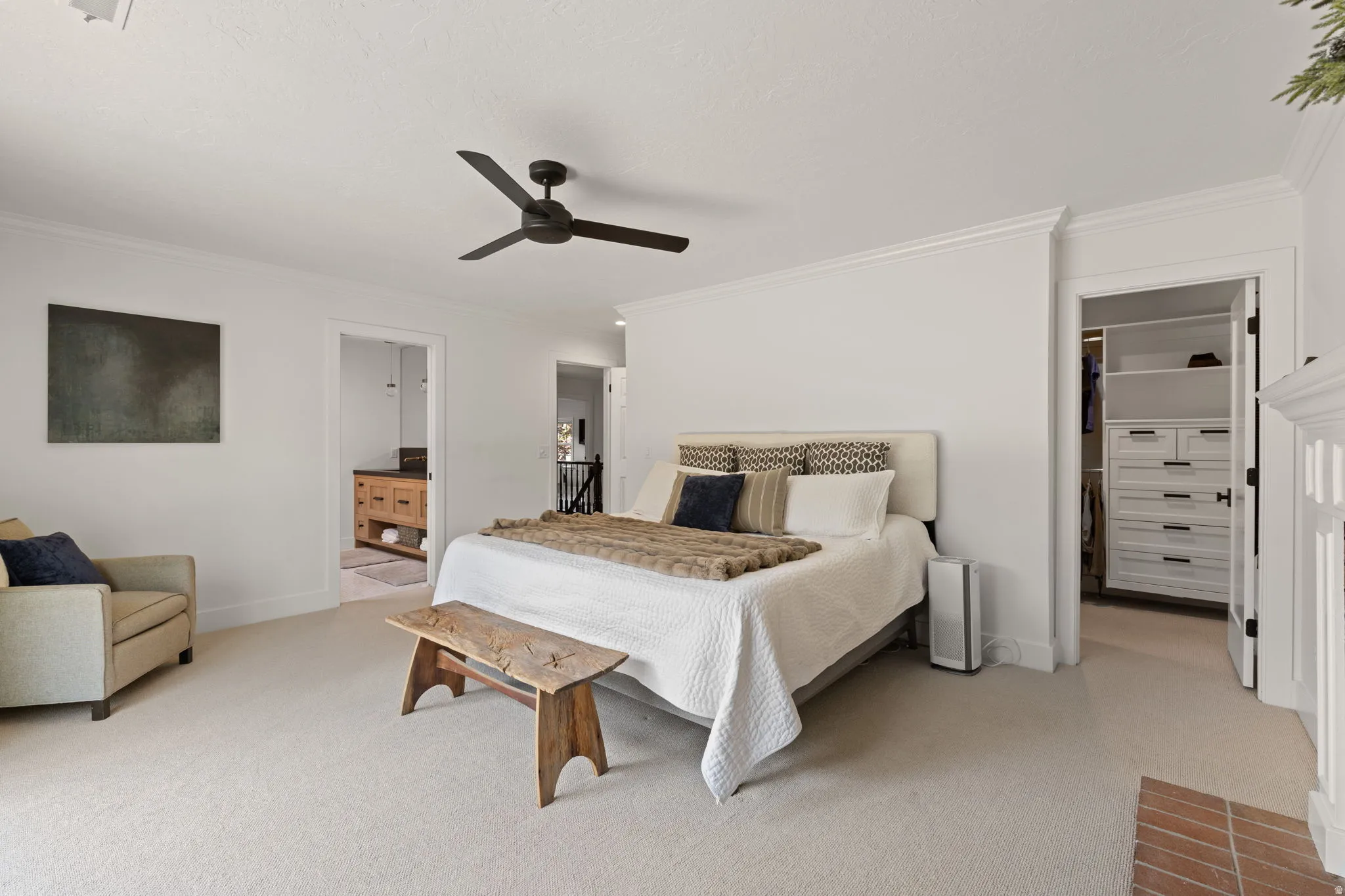 Bedroom featuring a spacious closet, ornamental molding, light carpet, and ceiling fan