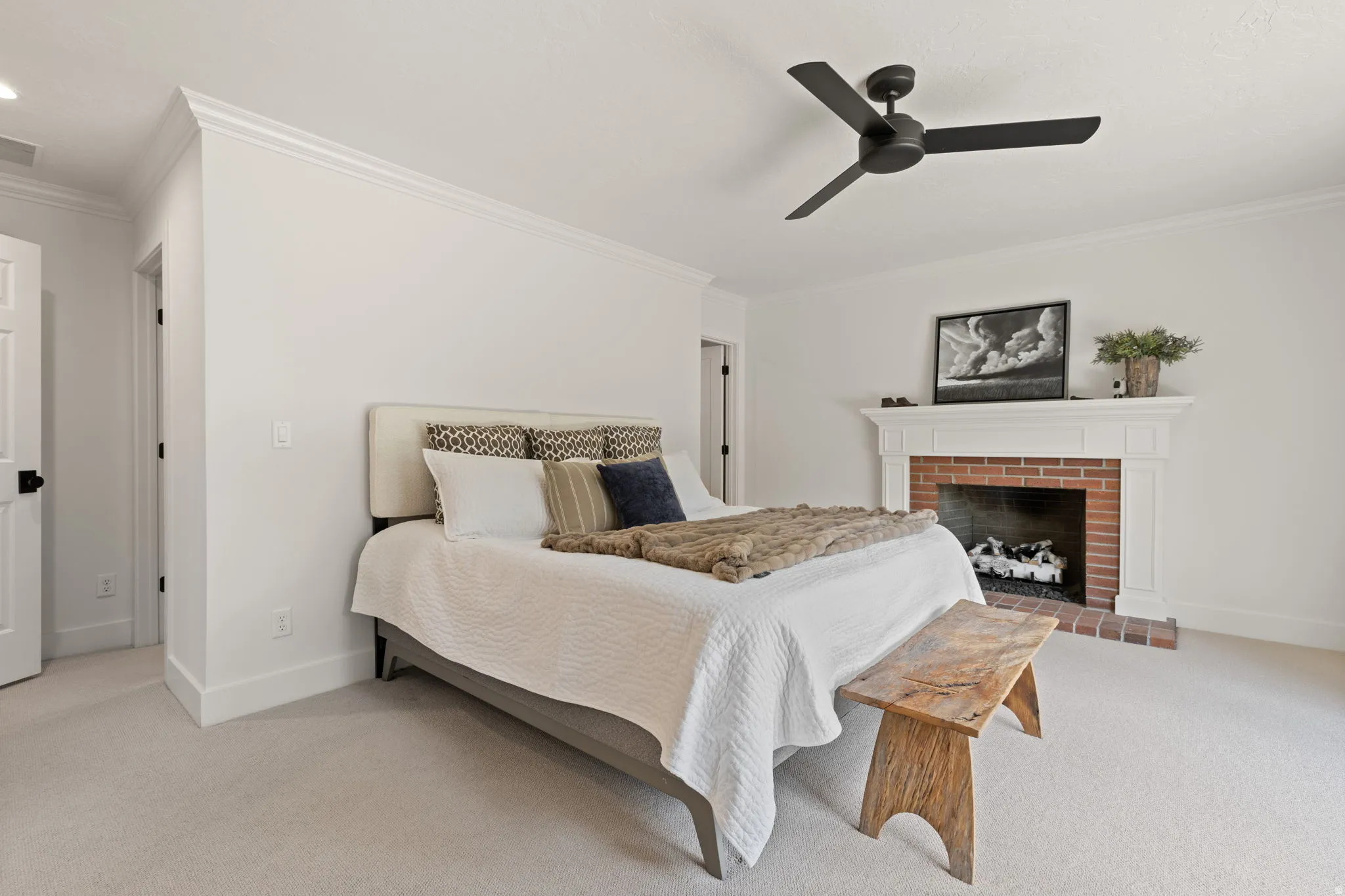Bedroom featuring ornamental molding, light colored carpet, a ceiling fan, and a fireplace