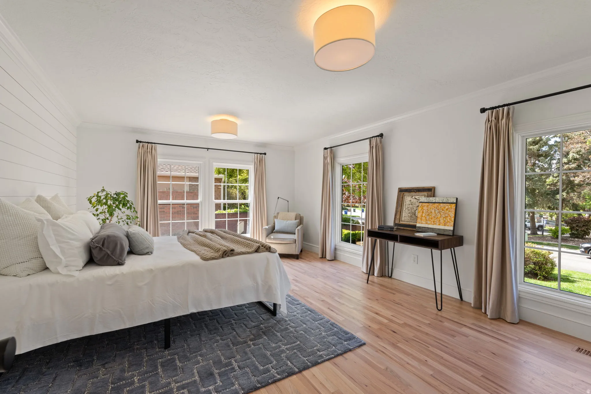 Bedroom with light wood-style floors and ornamental molding