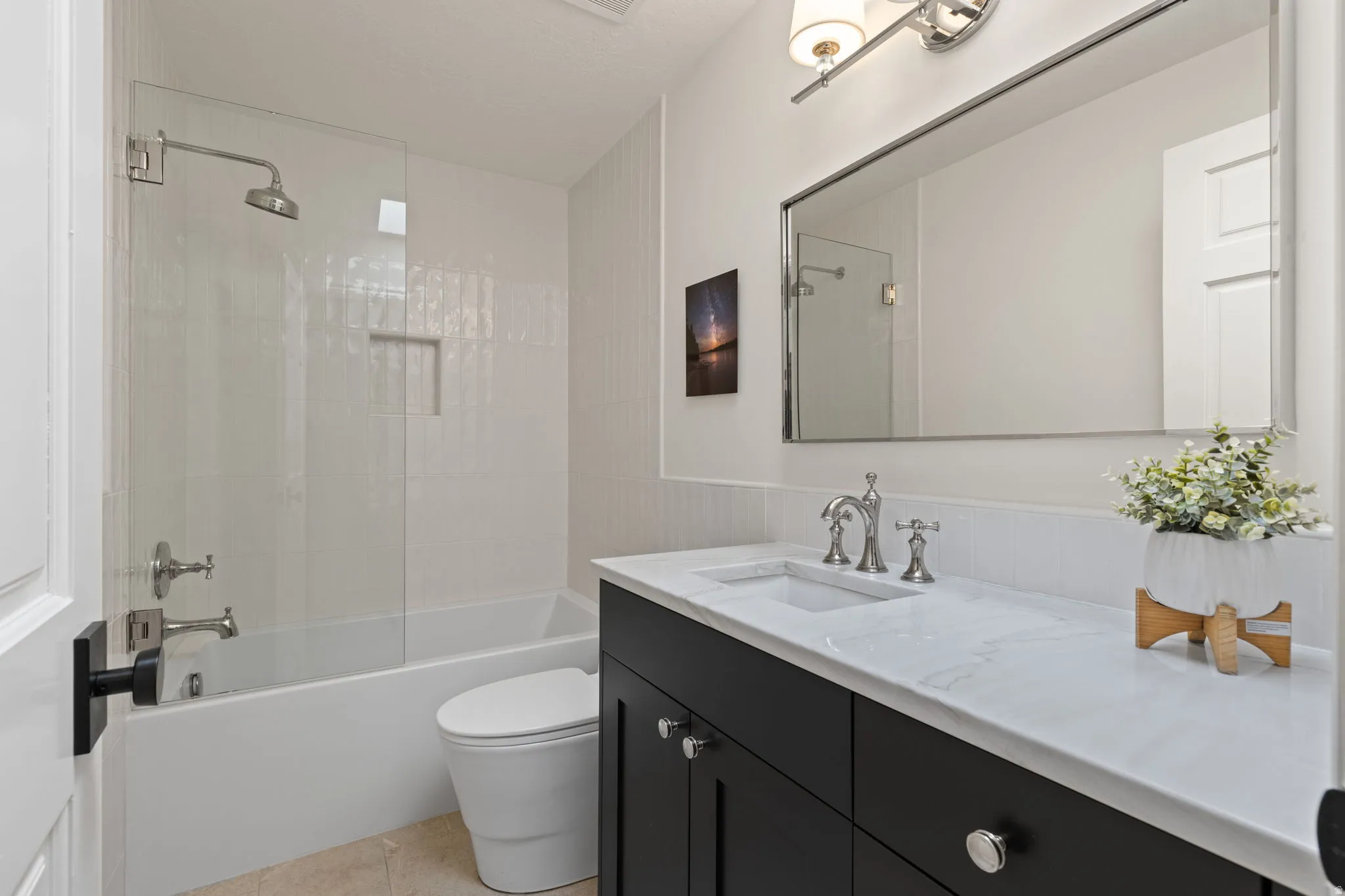 Bathroom with vanity, shower / tub combination, and light tile patterned floors