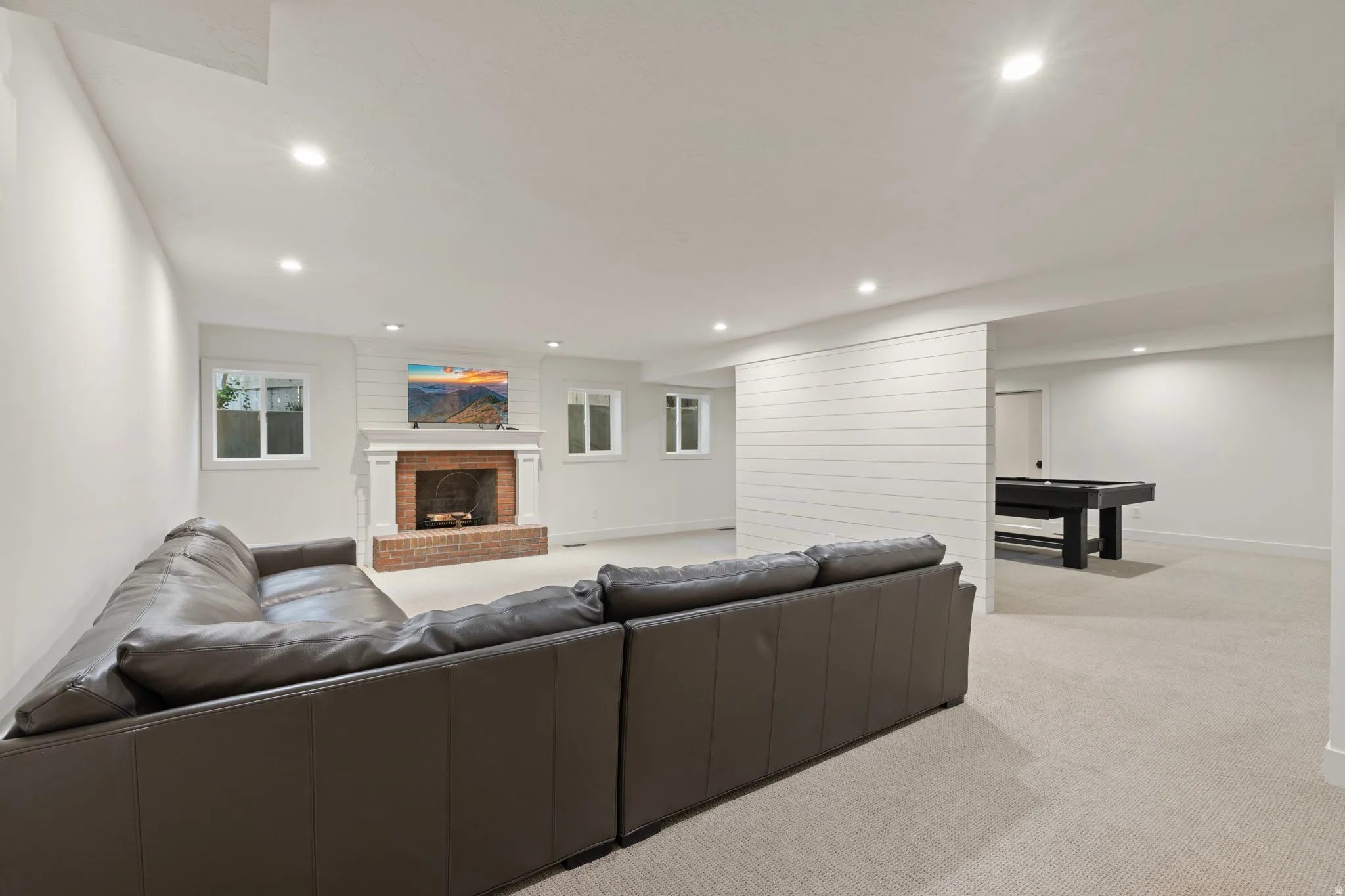 Living room featuring a fireplace, light carpet, and recessed lighting