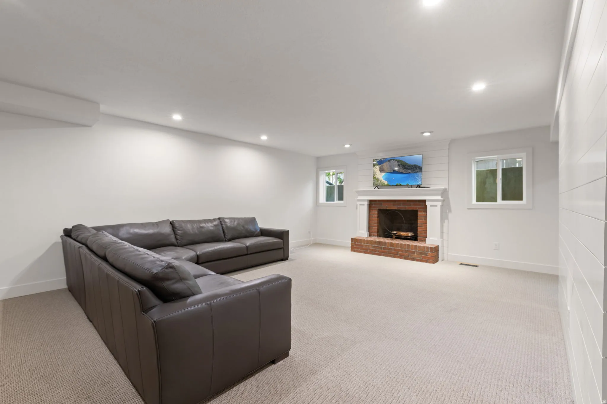 Living room with light carpet, a fireplace, and recessed lighting