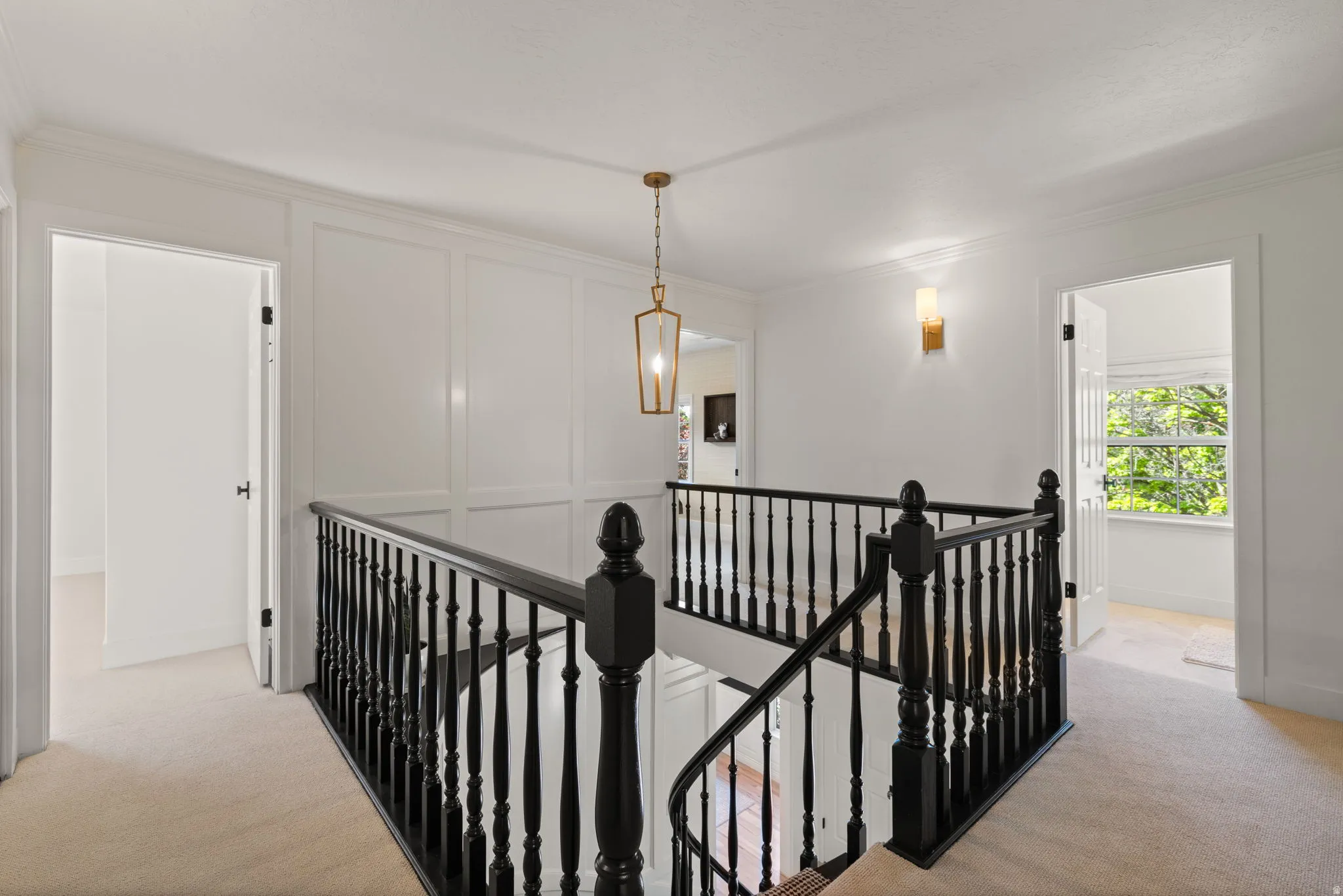 Corridor featuring an upstairs landing, light carpet, and ornamental molding