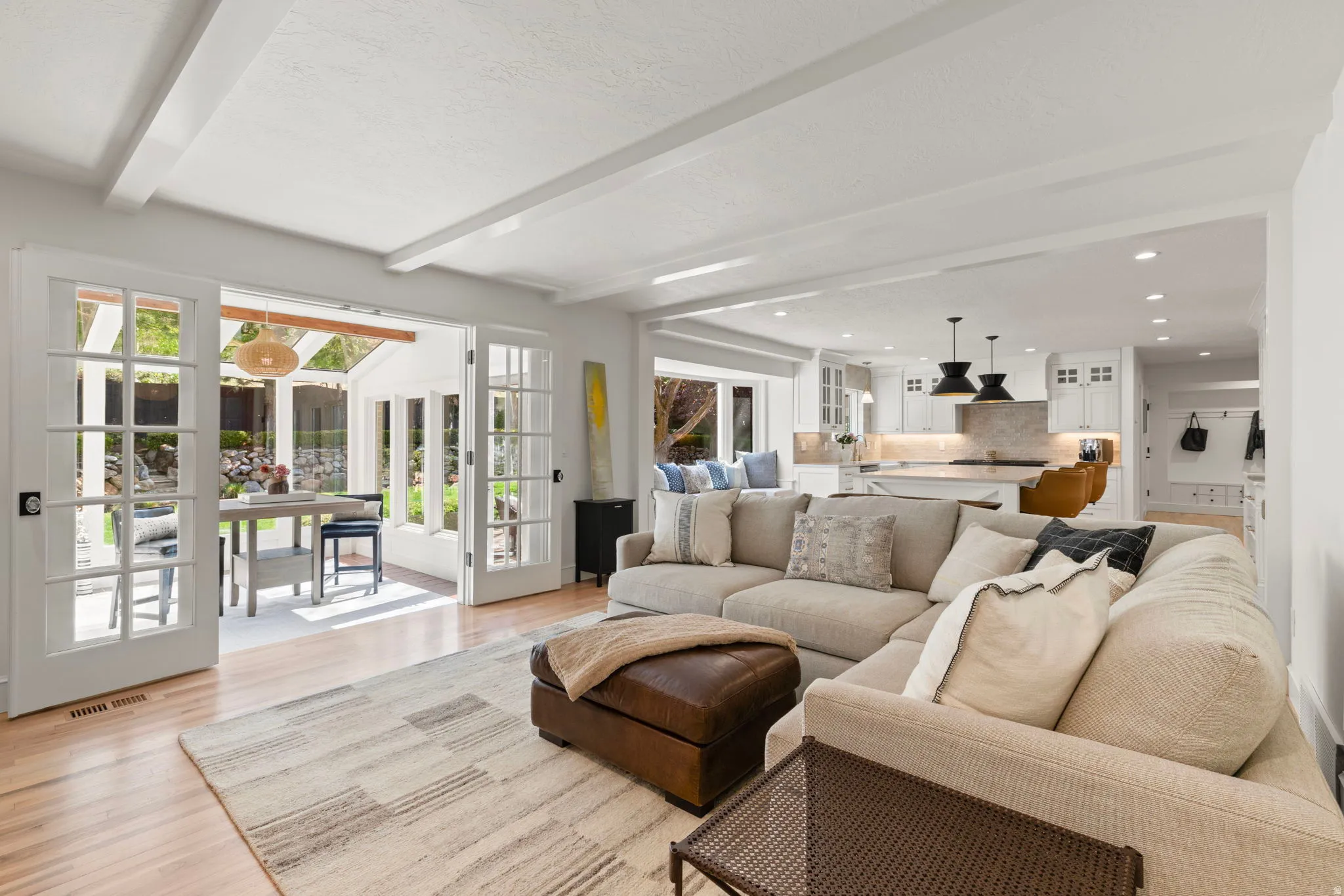 Living area featuring recessed lighting, light wood-style flooring, beamed ceiling, and french doors
