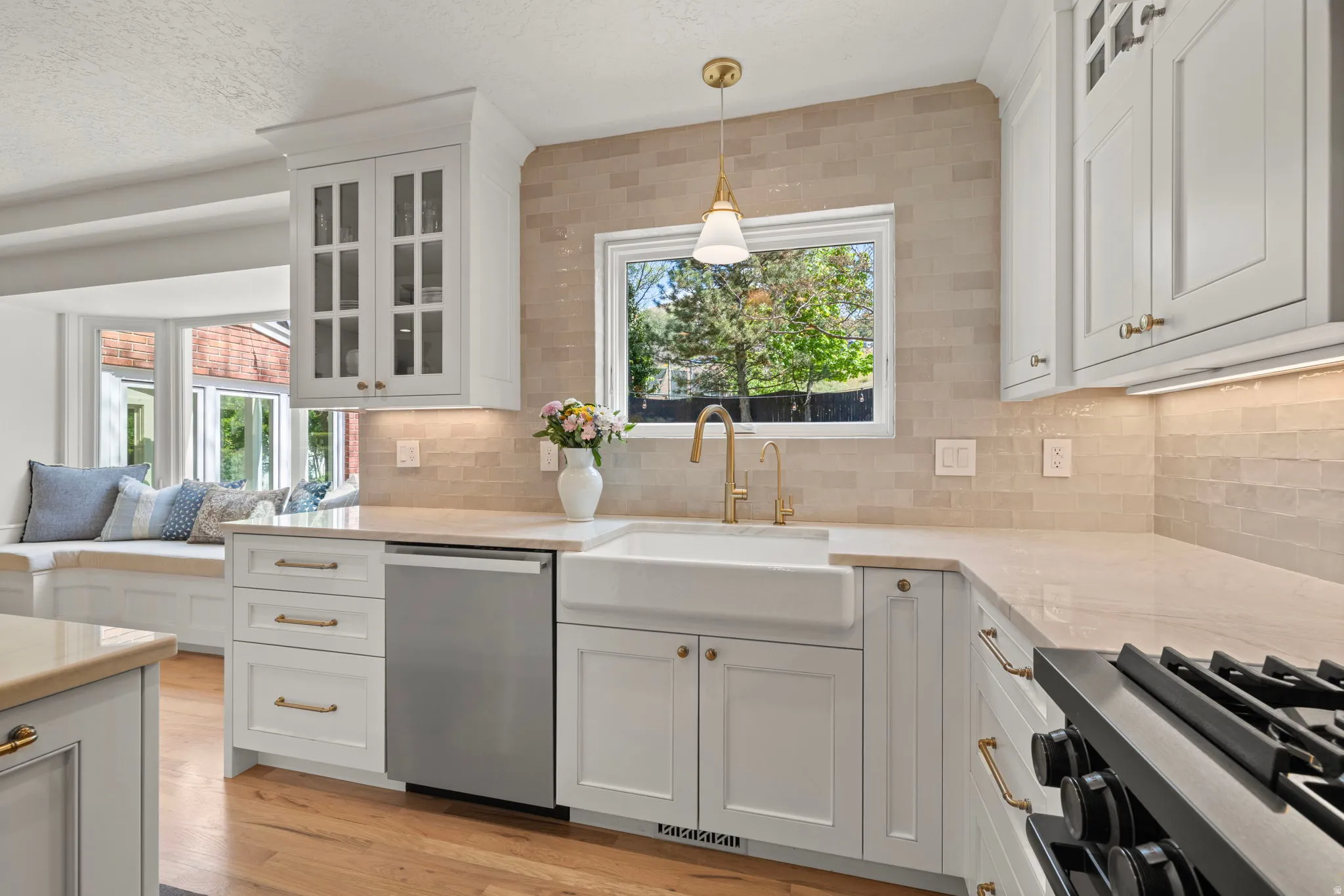 Kitchen featuring glass fronted cabinets, light stone countertops, white cabinetry, range with gas cooktop, and a textured ceiling