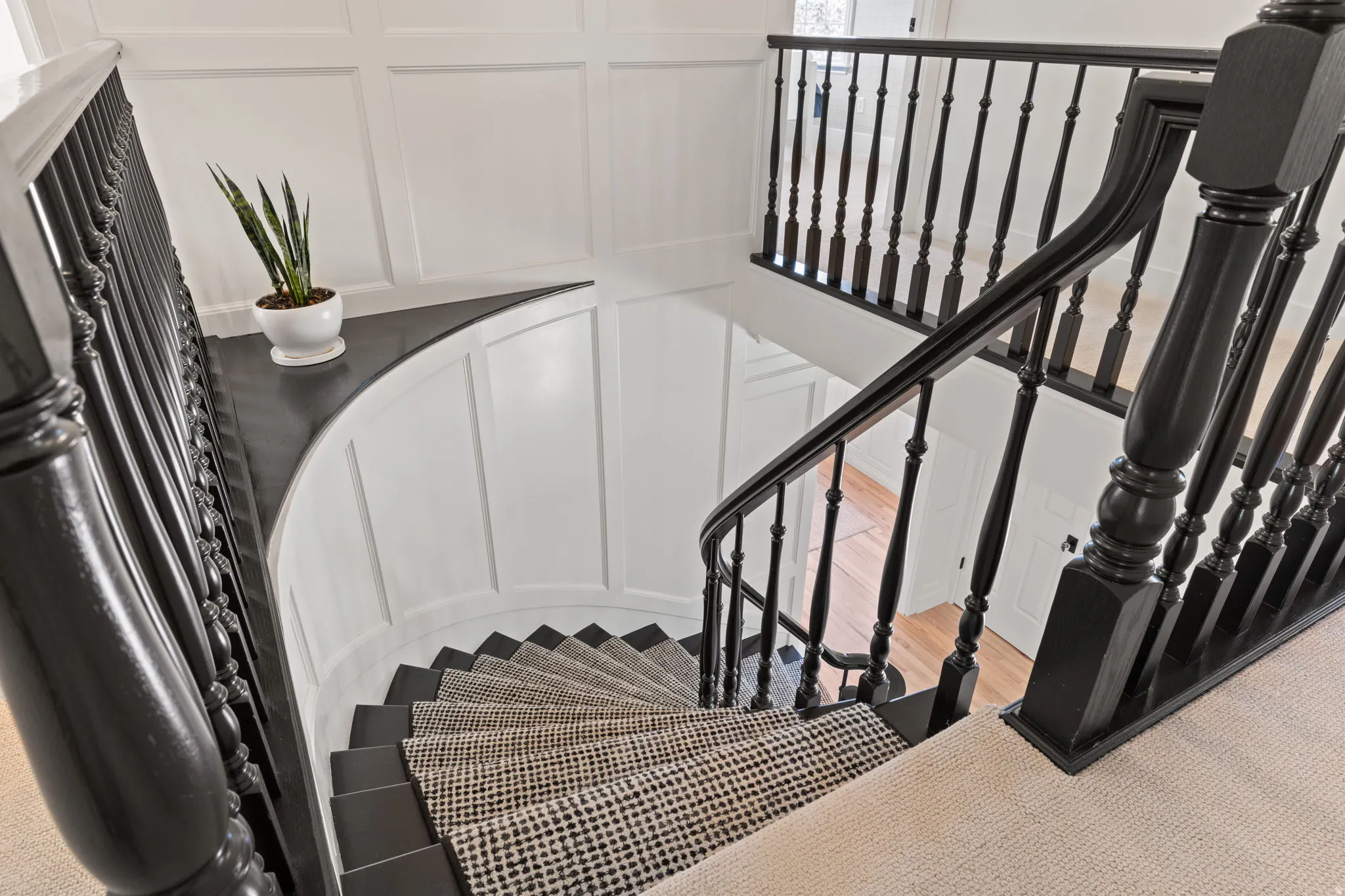 Stairs featuring a decorative wall and wood finished floors