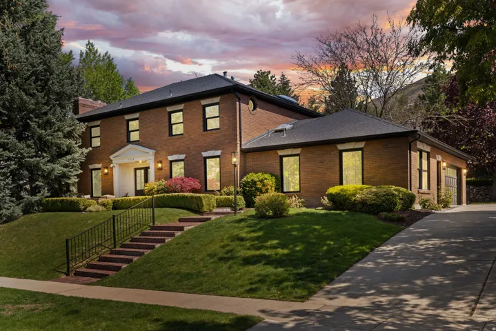 Colonial house with brick siding, a front lawn, and driveway