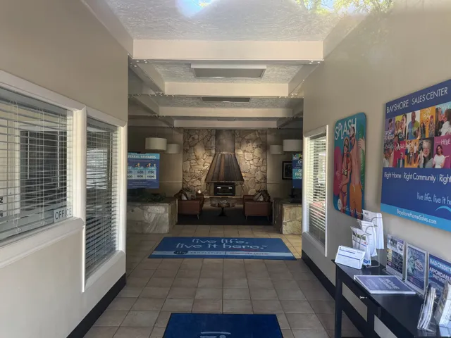 Entry hallway featuring tile flooring, recessed lighting, stone accent wall with a built-in fireplace, and interior windows with blinds